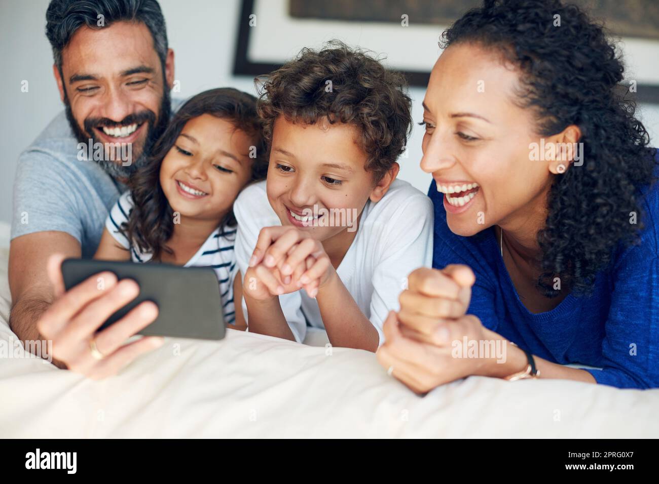 Mal sehen, dass das große Lächeln. Eine glückliche Familie macht ein Selfie zusammen zu Hause. Stockfoto