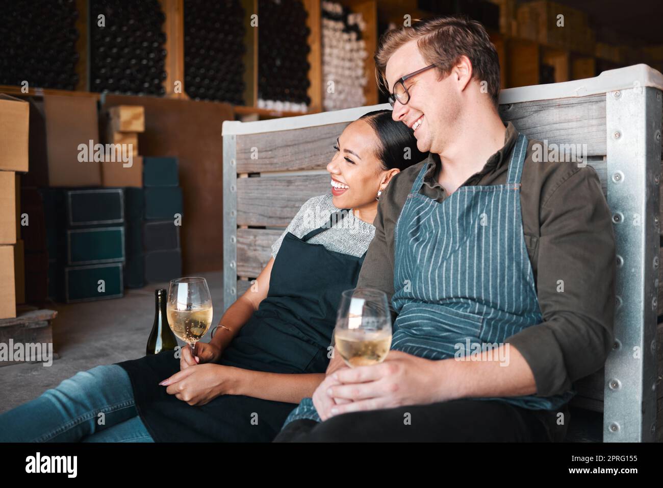 Lachende Freunde, Weinprobe und ein Paar mit einem fröhlichen Lächeln, das sich mit einem Glas Getränk auf dem Bauernhof auf dem Land anfreundet. Männer, Frauen oder Arbeiter aus der Branche in der Destillerie „Environmental Vineyard Restaurant“ Stockfoto