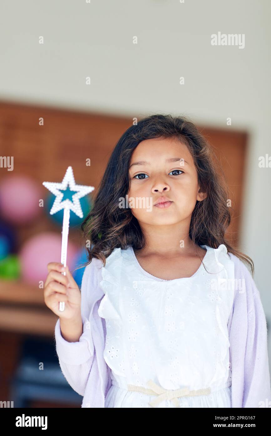 Wünsche wurden erfüllt. Portrait eines niedlichen kleinen Mädchens, das zu Hause mit einem Zauberstab spielt. Stockfoto