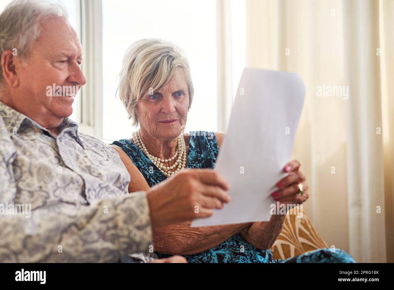 Ein Seniorenpaar, das zu Hause ihre Papiere gemeinsam durchläuft, hat ihren Pensionsplan genau im Auge. Stockfoto