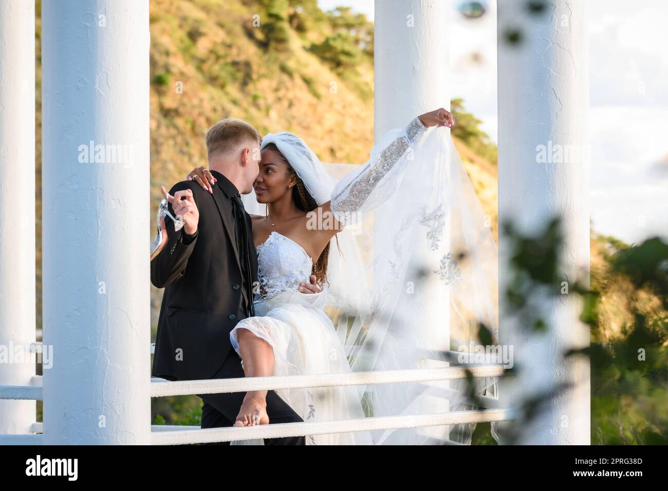 Junge schöne interracial Brautpaar Umarmung in der Pavillon Stockfoto