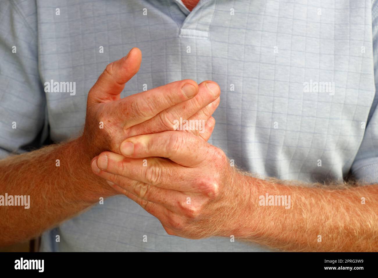 Linksseitige Finger eines Mannes, der seine rechte Hand und seinen Knöchel massiert Stockfoto