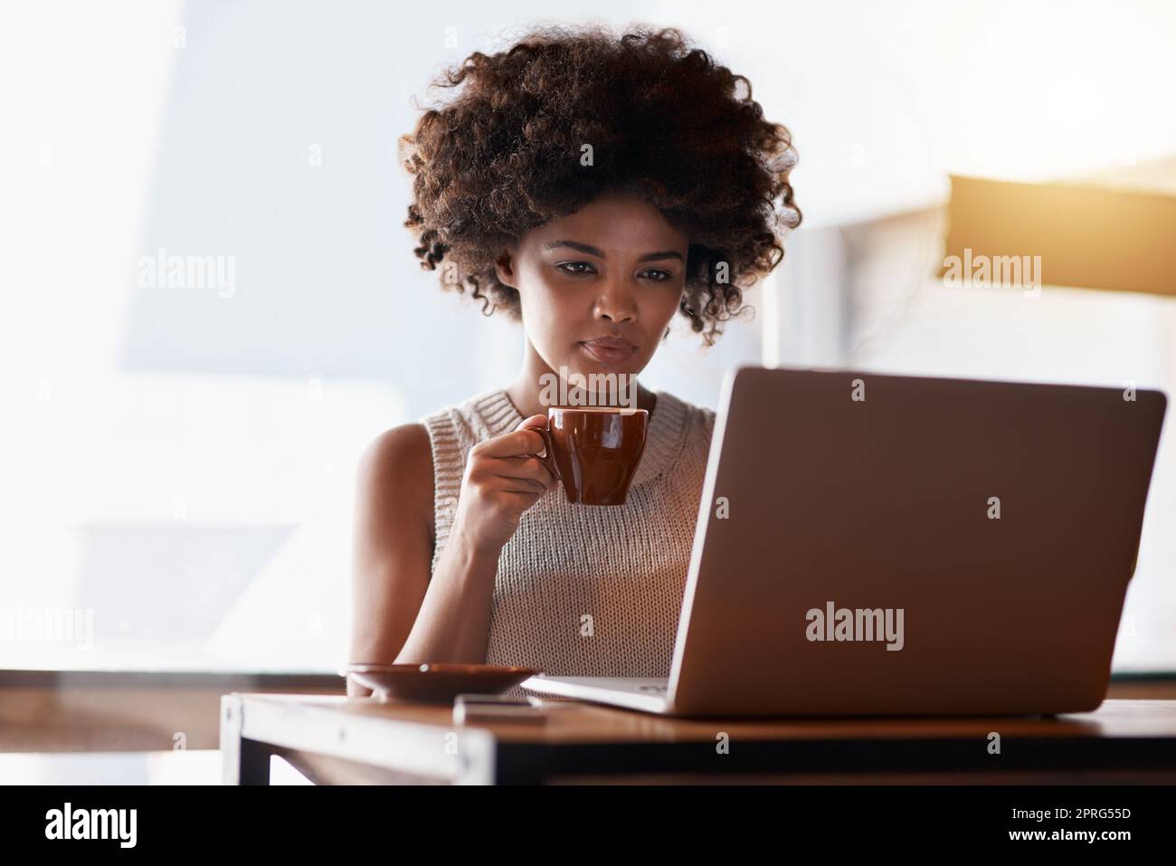 Beginnen Sie klein und bauen Sie auf Ihrem Erfolg. Ein junger Unternehmer mit einem Laptop, während sie in ihrem Café sitzen. Stockfoto