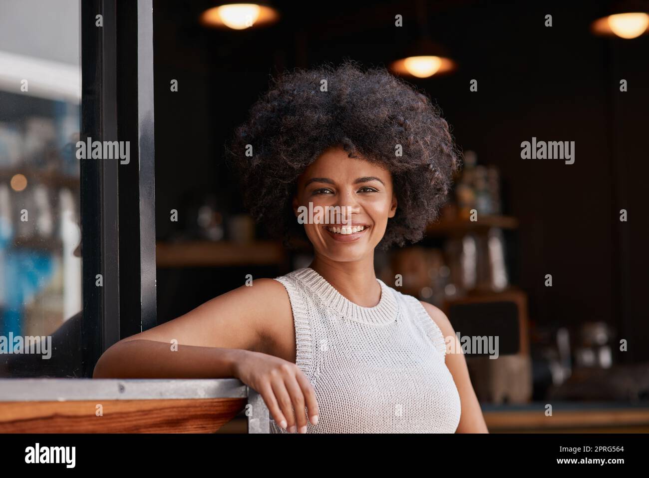 Es gibt einen Unternehmer in uns allen. Porträt einer selbstbewussten jungen Geschäftsbesitzerin, die vor der Tür ihres Cafés posiert. Stockfoto