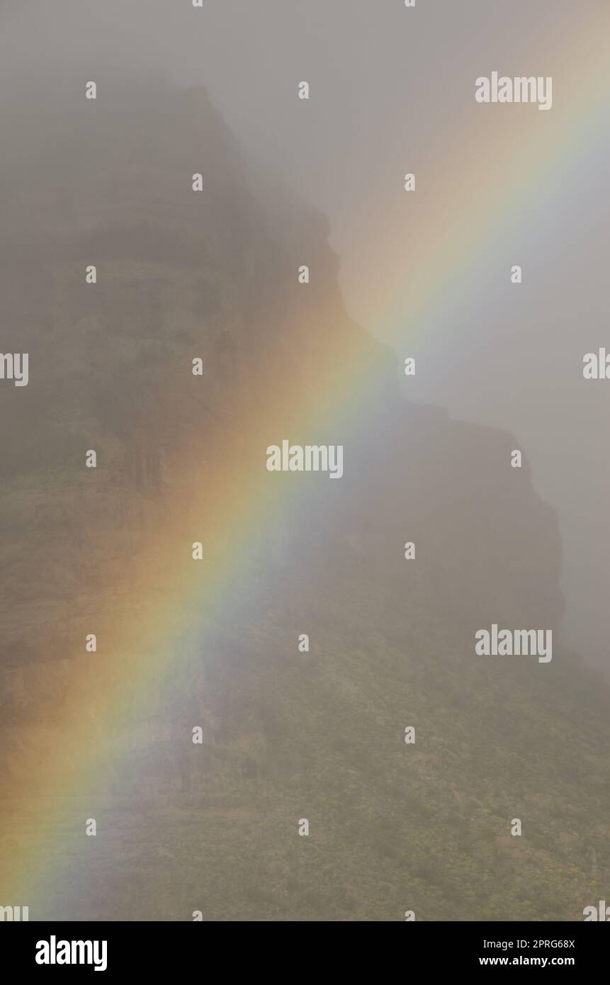 Regenbogen- und Tirajana-Klippen im Nebel. Stockfoto