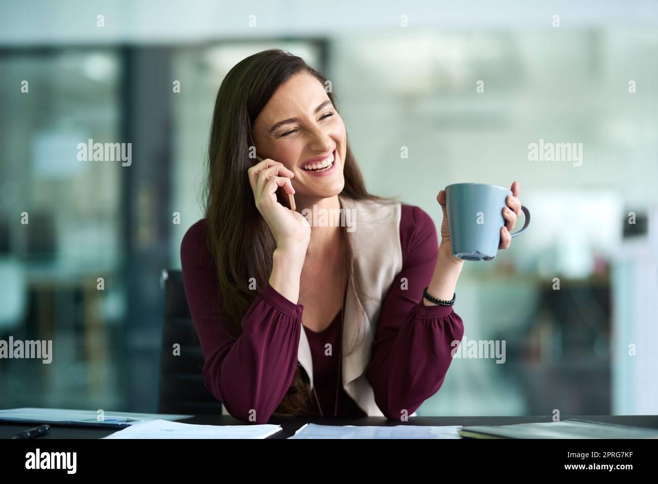Ich bin motiviert, alle Bedürfnisse meiner Kunden zu erfüllen. Eine Geschäftsfrau, die im Büro auf ihrem Handy spricht. Stockfoto