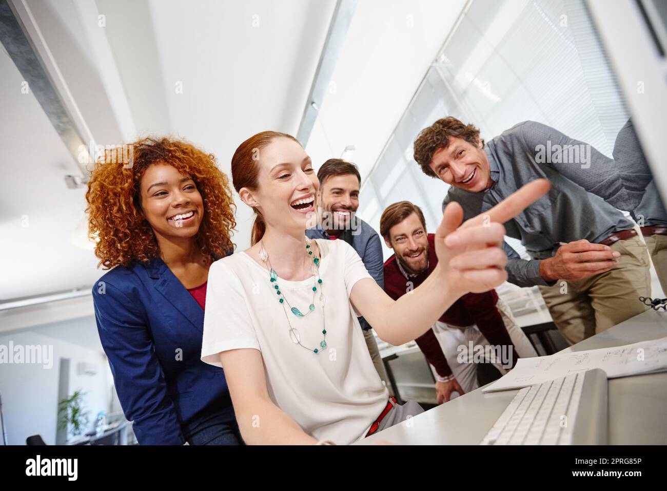 Social Media findet ihren Platz in jedem Büro. Eine Gruppe von Geschäftsleuten, die im Büro gemeinsam einen Computer betrachten. Stockfoto