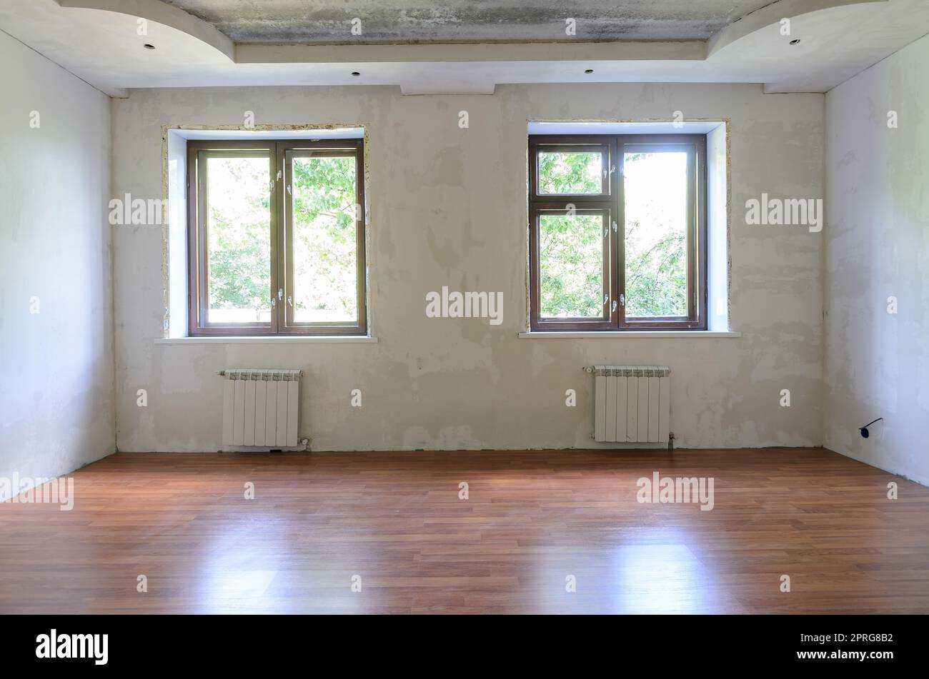 Innenraum des leeren Zimmers während der Renovierung, Blick auf die Wand mit Fenstern Stockfoto