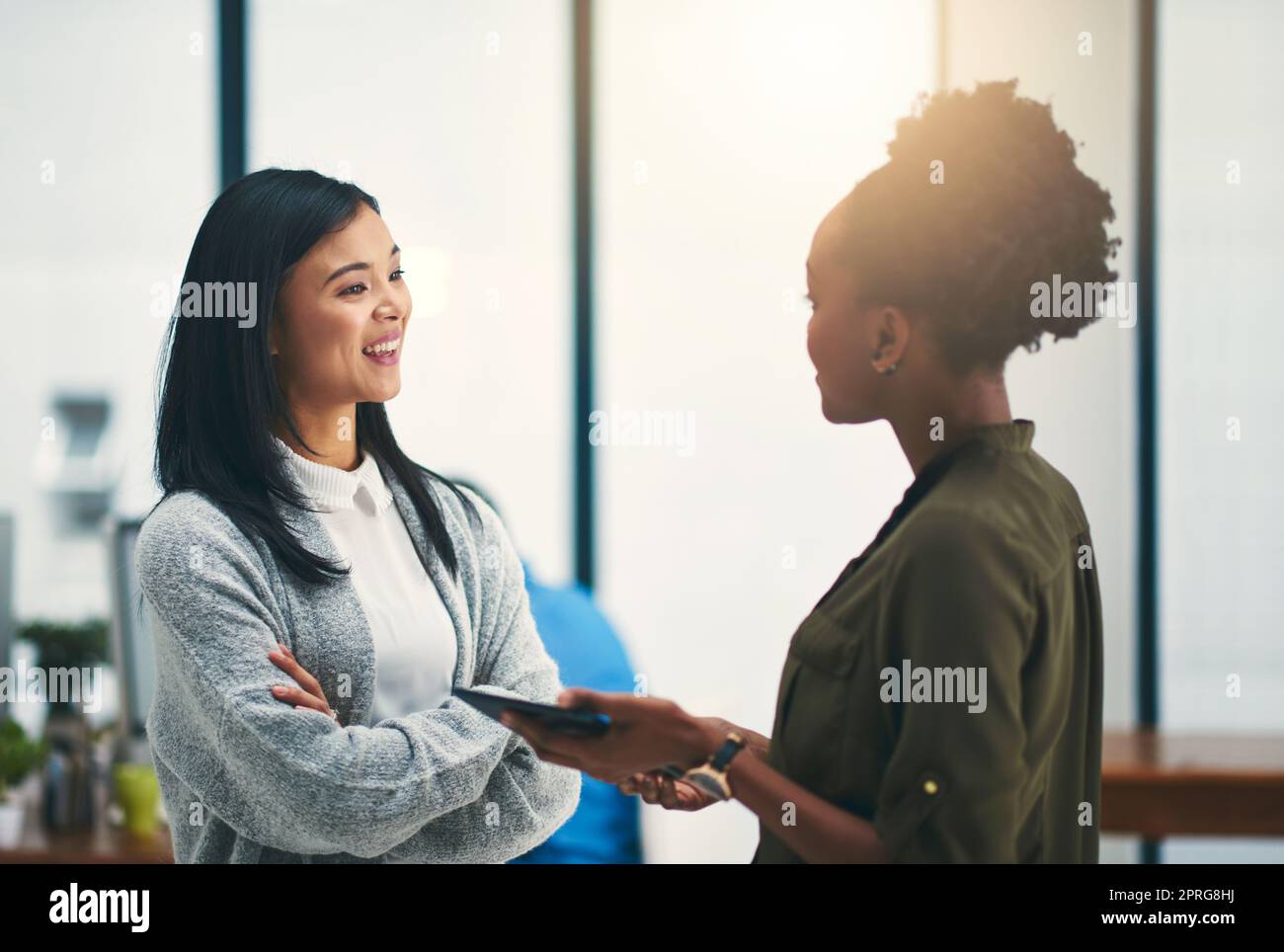 Sie teilen den gleichen Anspruch auf Erfolg: Zwei junge Kreative, die in einem Büro diskutieren. Stockfoto