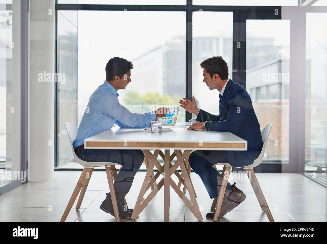 Kollaborative Fähigkeiten sind für den Erfolg unerlässlich. Zwei Geschäftsleute, die während einer Besprechung im Büro ein digitales Tablet verwenden. Stockfoto