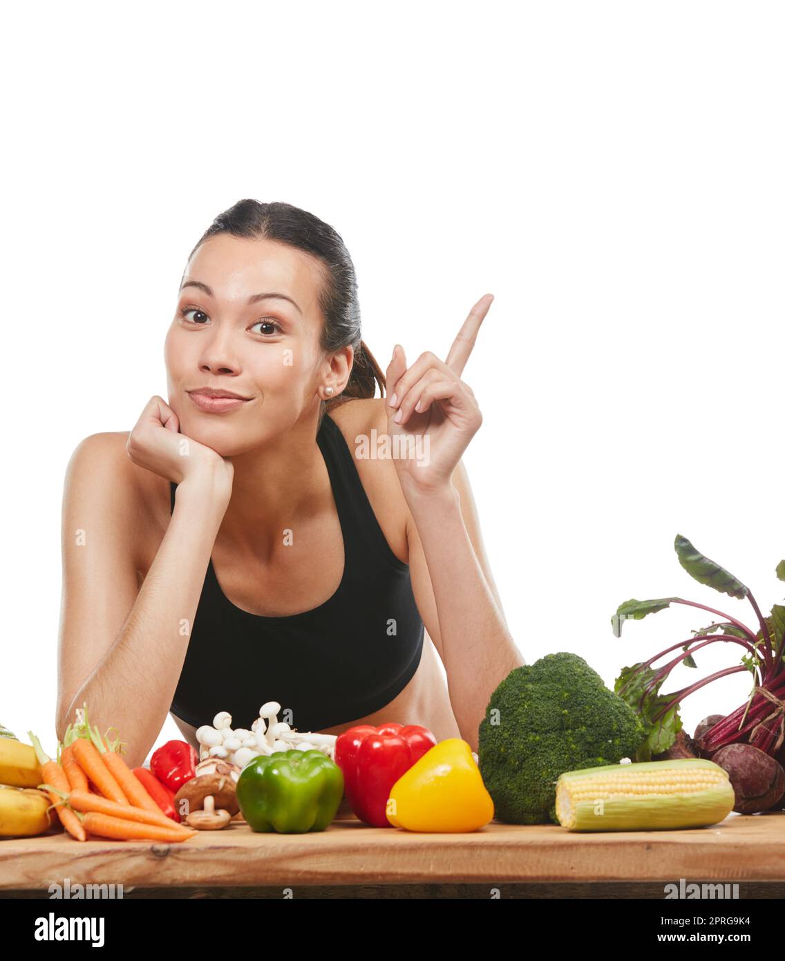 Ihre Gesundheit ist es wert, beachtet zu werden. Studioporträt einer attraktiven jungen Frau mit einem Tisch voller Gemüse vor weißem Hintergrund. Stockfoto