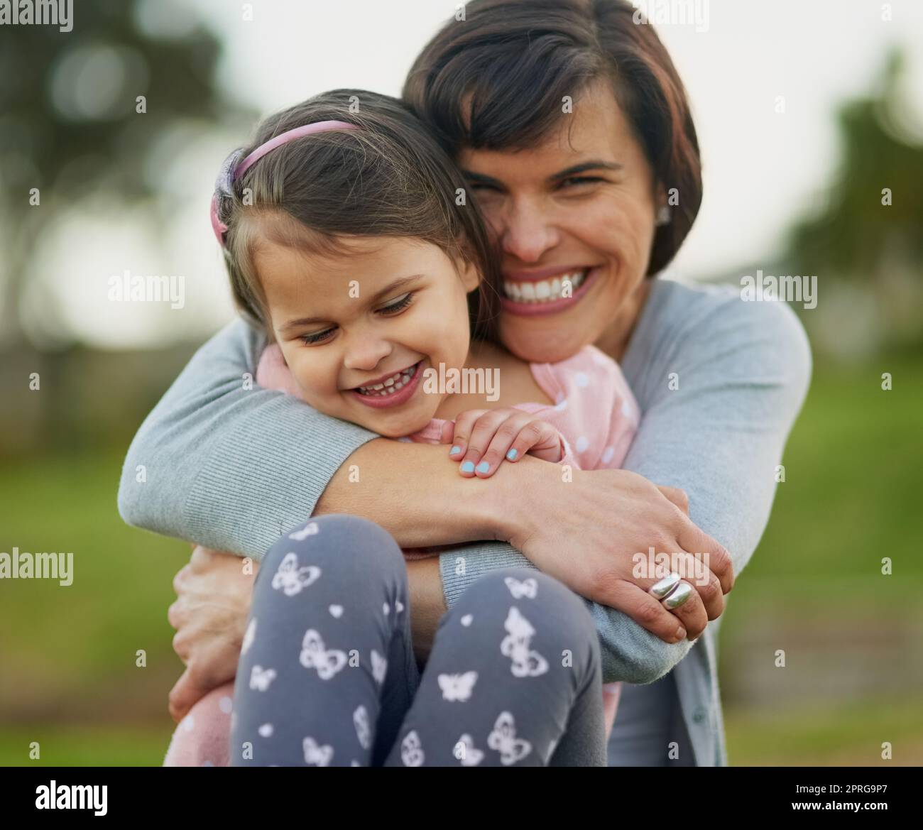 Kuschelt mich nach meinem kleinen Jungen. Porträt einer Mutter und Tochter, die eine gute Zeit zusammen im Freien genießen. Stockfoto