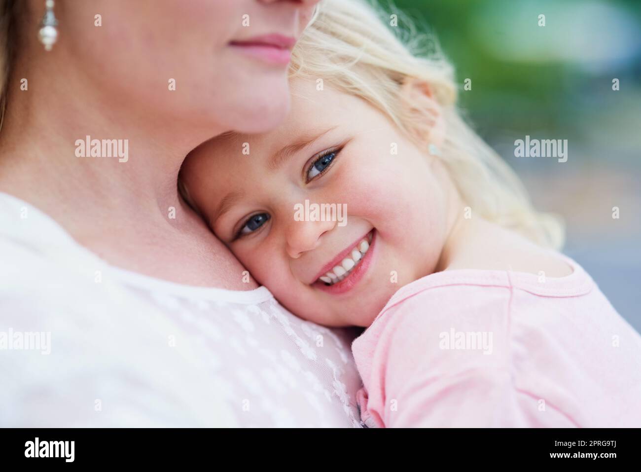 Meine Mummys die beste. Porträt eines niedlichen kleinen Mädchens, das von ihrer Mutter draußen gehalten wird. Stockfoto