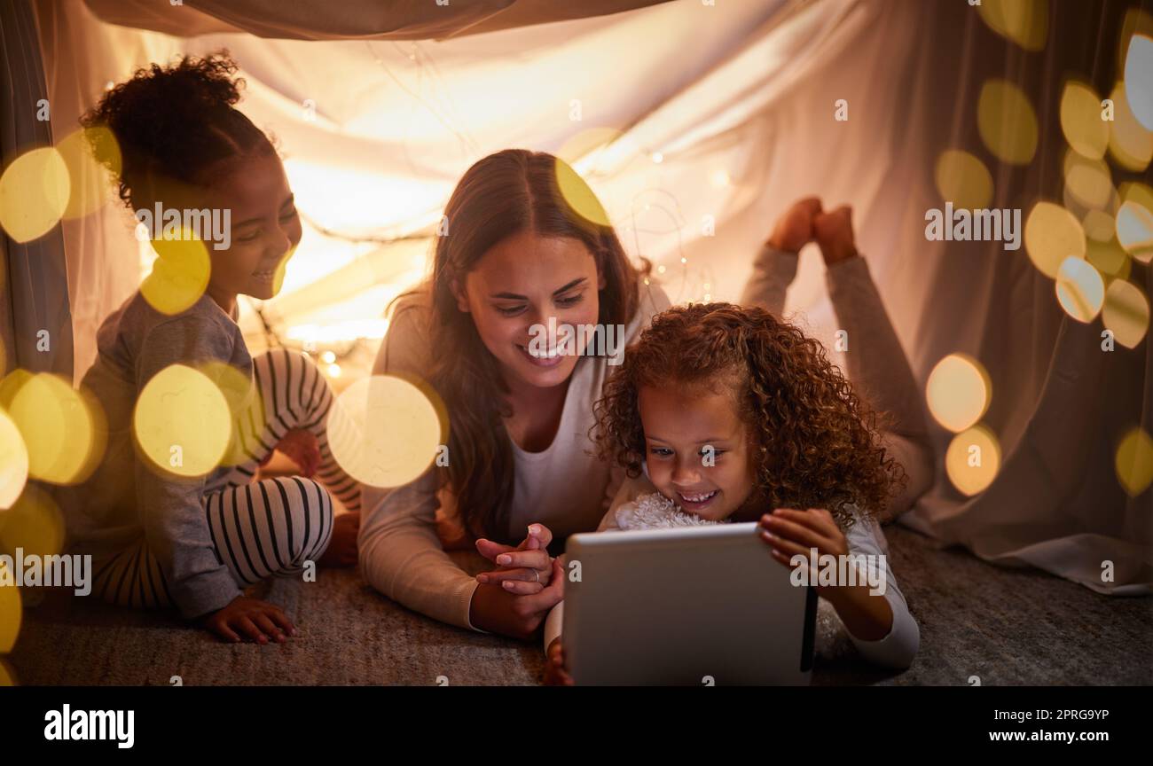 Mutter, Kinder und ein Tablet mit glücklicher Familie schauen online fern, lernen mit Lernspielen und lesen E-Books in der Nacht zu Hause. Internet und Live-Streaming von Filmen mit Cartoon-Abonnement Stockfoto