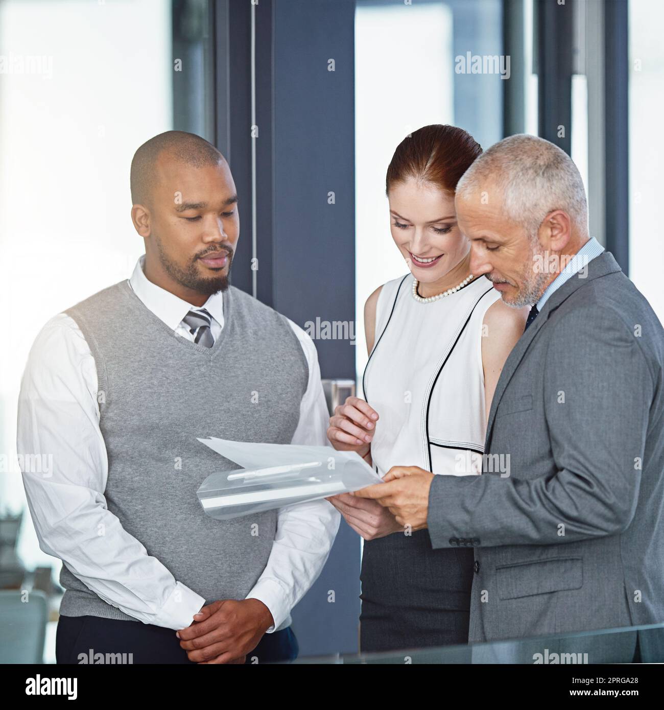 Diese sehen bisher alles in Ordnung aus. Eine Gruppe von Geschäftsleuten, die gemeinsam in einem Büro einige Papiere durchsuchten. Stockfoto