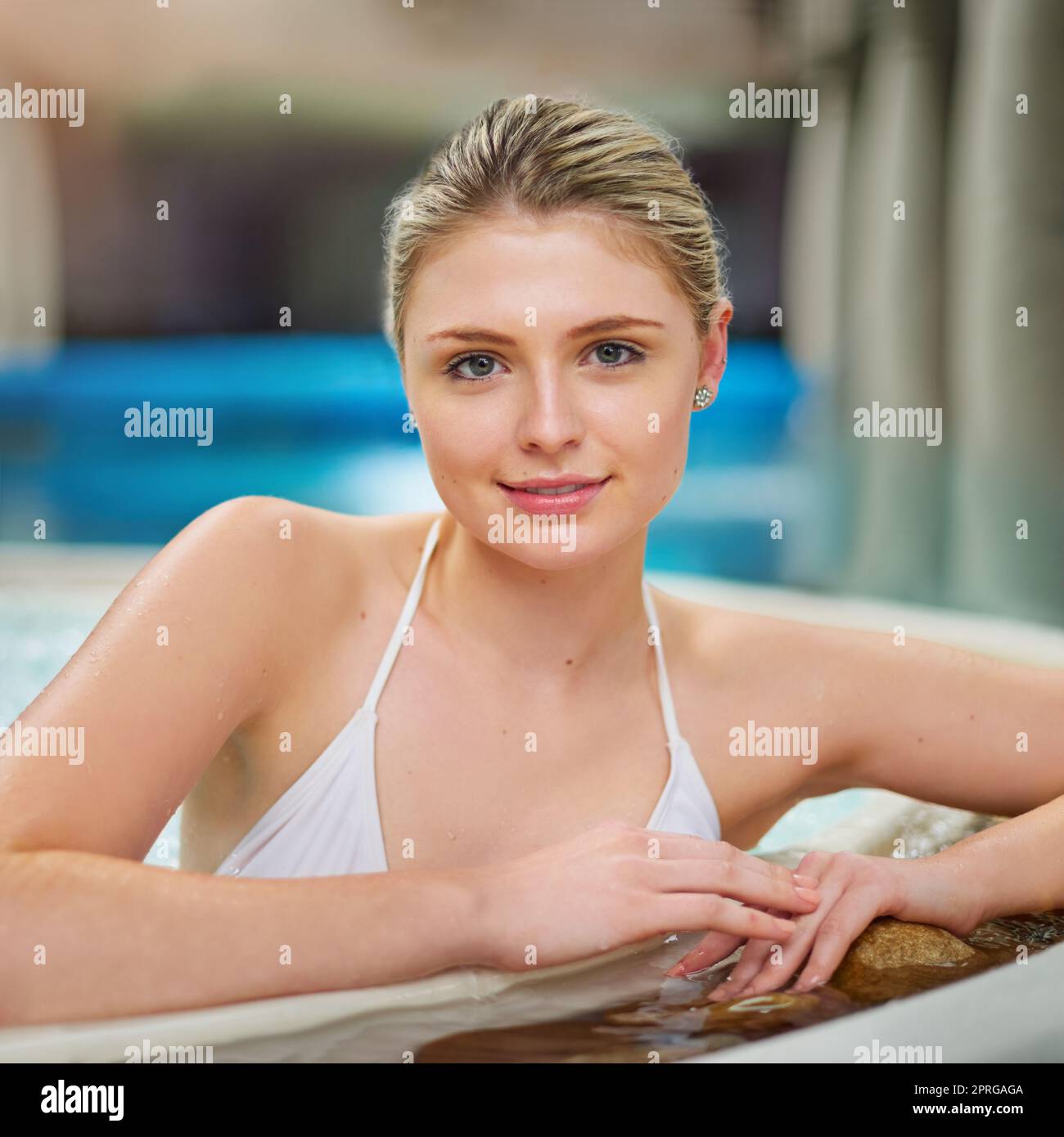 Heute mache ich mich zu einer Priorität. Porträt einer jungen Frau, die sich im Whirlpool in einem Spa entspannt. Stockfoto