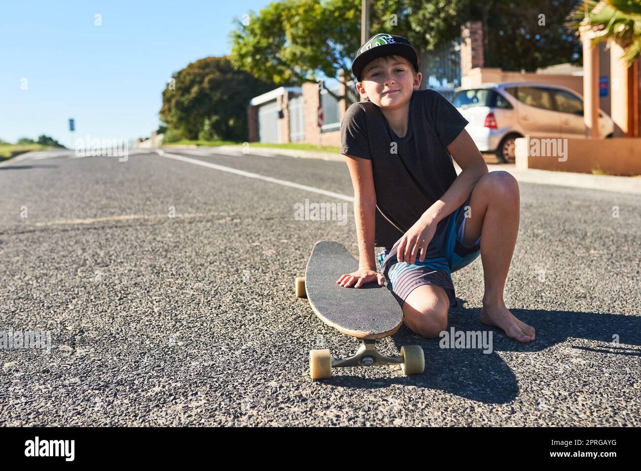 Ich bin ein toller Skater. Porträt eines jungen Jungen, der mit seinem Longboard auf der Straße spielt. Stockfoto