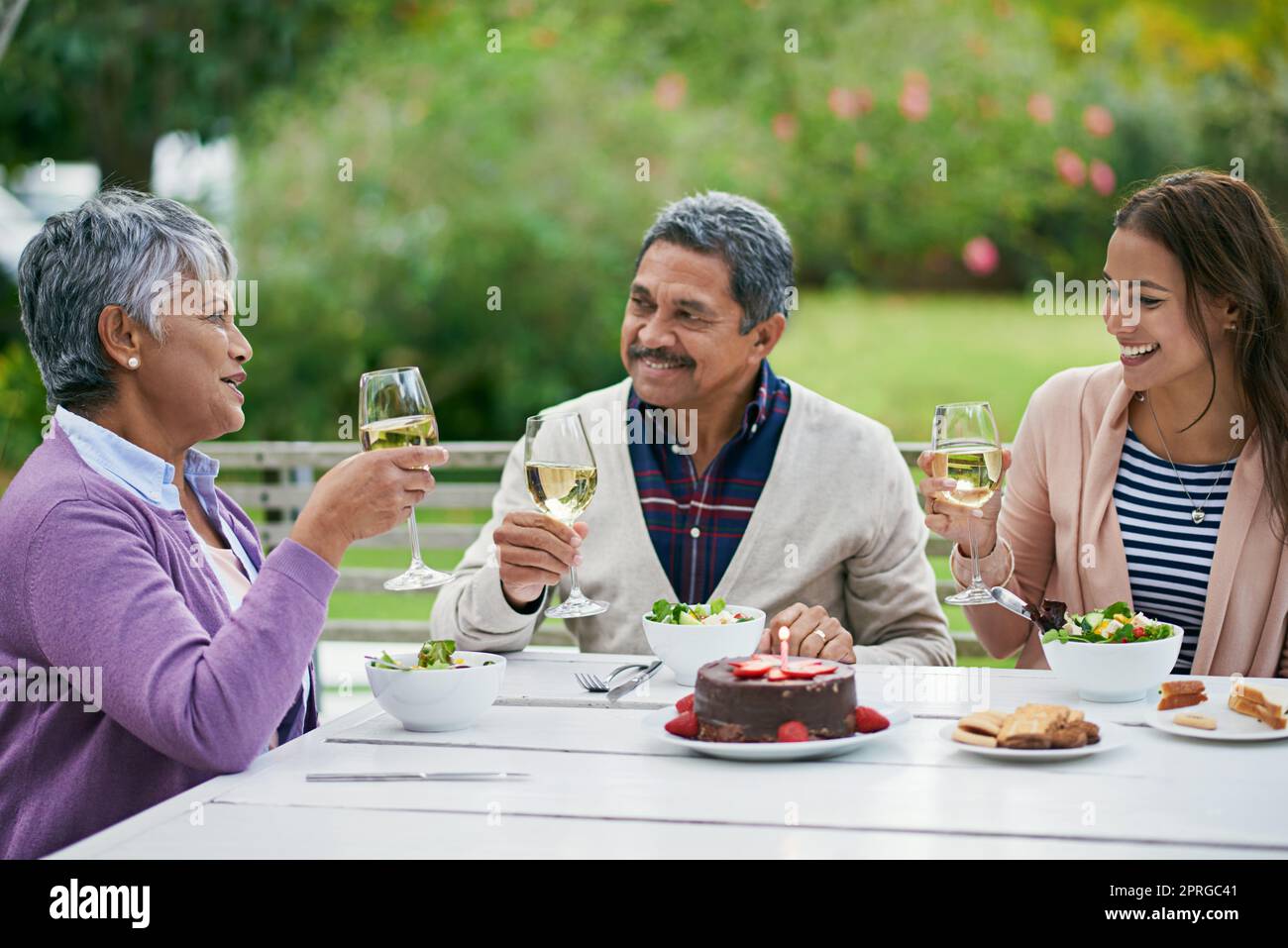 Viele glückliche Rückkehr, meine Liebe. Eine Familie genießt ein Geburtstagsessen draußen. Stockfoto