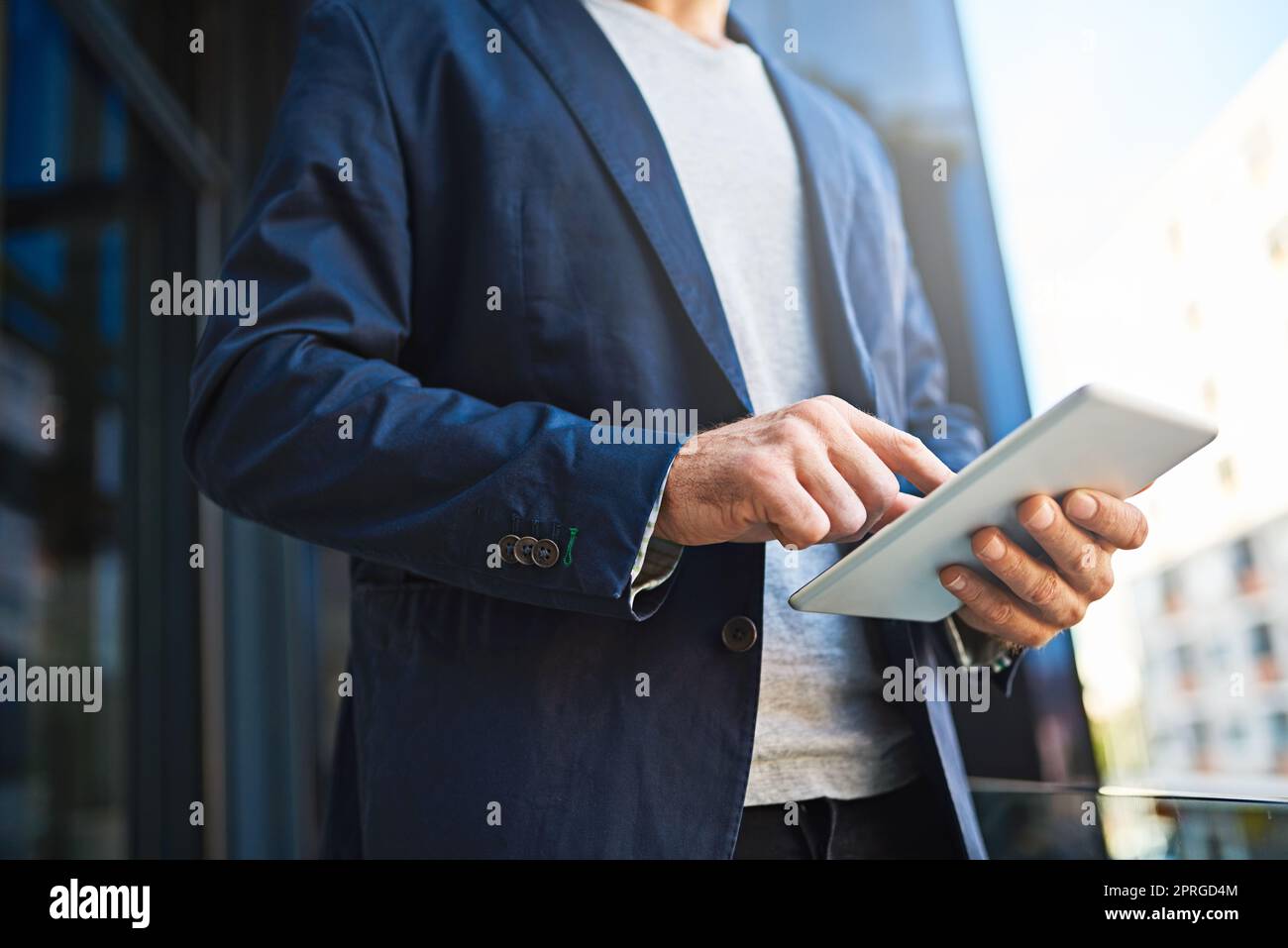 Die Technologie verschafft ihm den Wettbewerbsvorteil. Ein nicht erkennbarer Geschäftsmann, der sein Tablet benutzt, während er auf einem Balkon steht. Stockfoto
