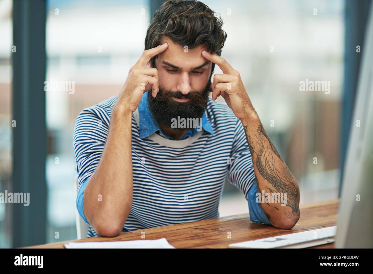 Ich habe so viele Ideen in meinem Kopf. Ein kreativer Geschäftsmann sitzt an seinem Schreibtisch in seinem Büro. Stockfoto