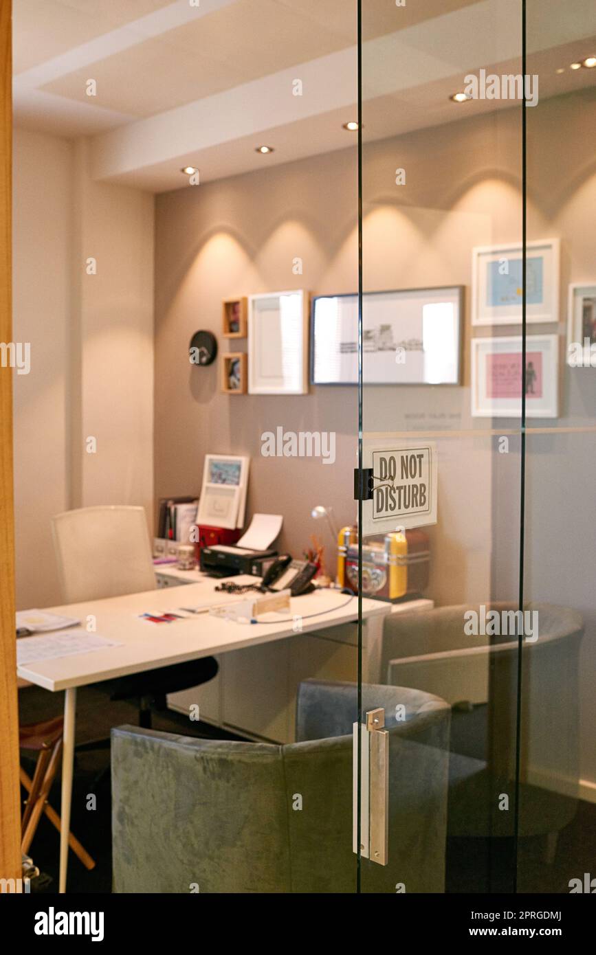 Wo sich der CEO um das Geschäft kümmert. Ein leeres Büro mit einem „Bitte nicht stören“-Schild im Fenster. Stockfoto