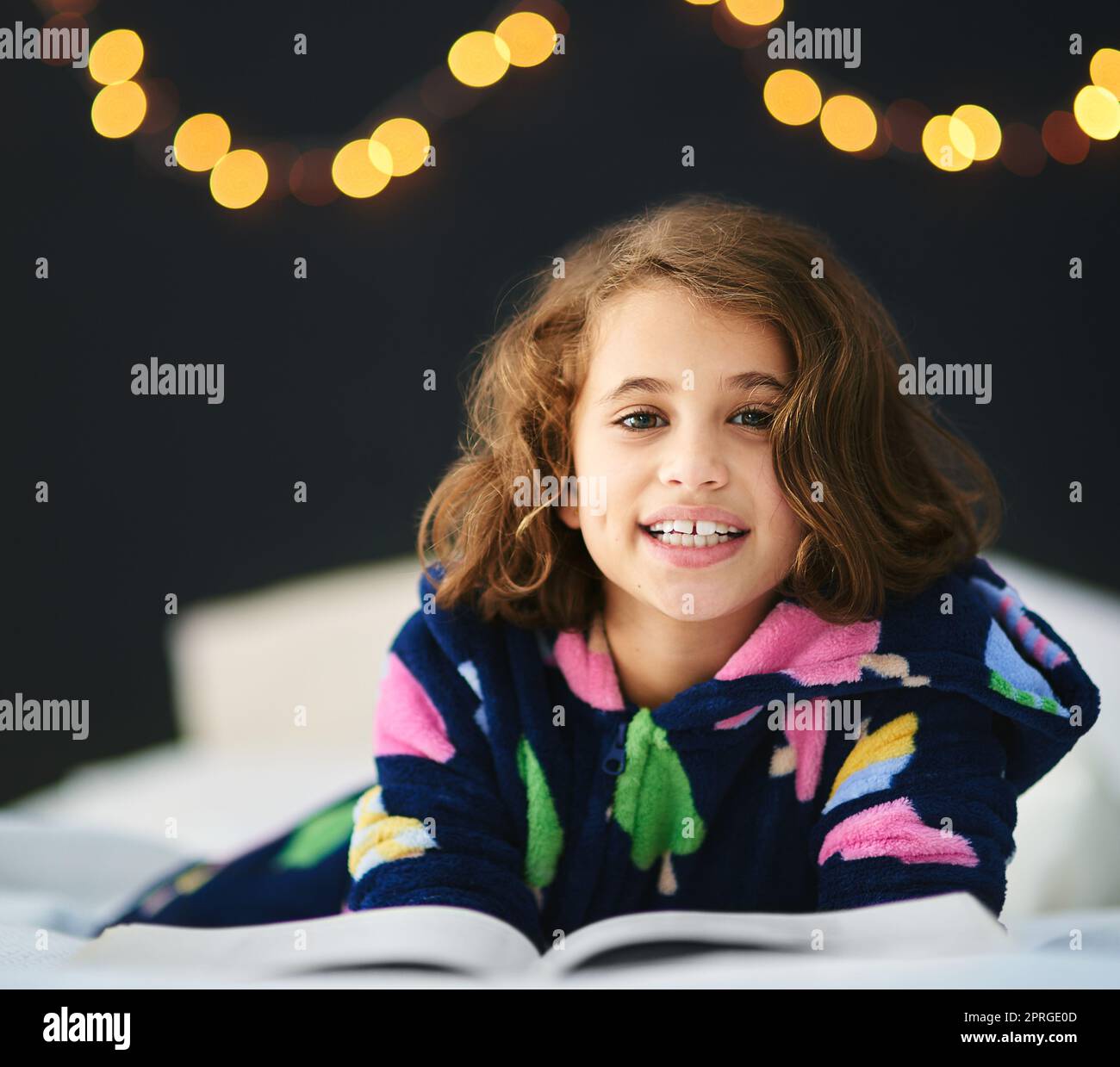 Ihr Lieblingsmärchen. Ein junges Mädchen liegt und liest im Bett. Stockfoto
