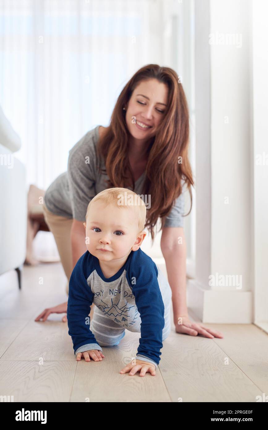 Er kroch direkt in ihr Herz. Eine Mutter und ihr Baby krochen zu Hause zusammen. Stockfoto