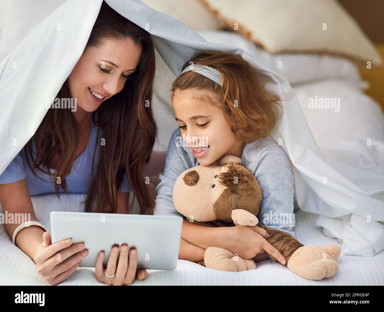 Genießen Sie den Morgen im Bett. Eine Mutter und ihre Tochter mit einem digitalen Tablet. Stockfoto