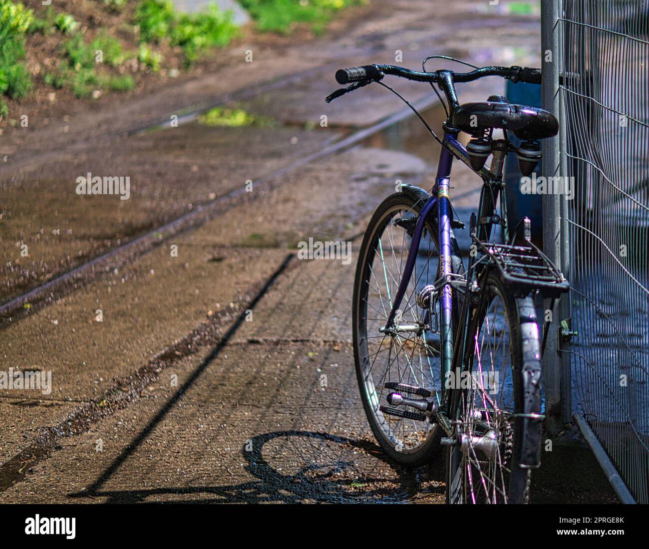 Geparktes Fahrrad an einem Bauzaun in Berlin. Stockfoto