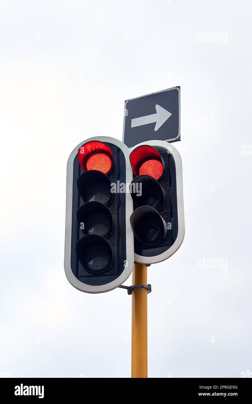 Halten Sie in alle Richtungen. Ampel vor einem grauen Himmel. Stockfoto