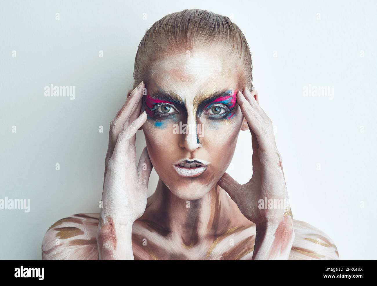 Bunte Illusionen. Studioportrait einer jungen Frau, die mit Farbe auf ihrem Gesicht posiert. Stockfoto