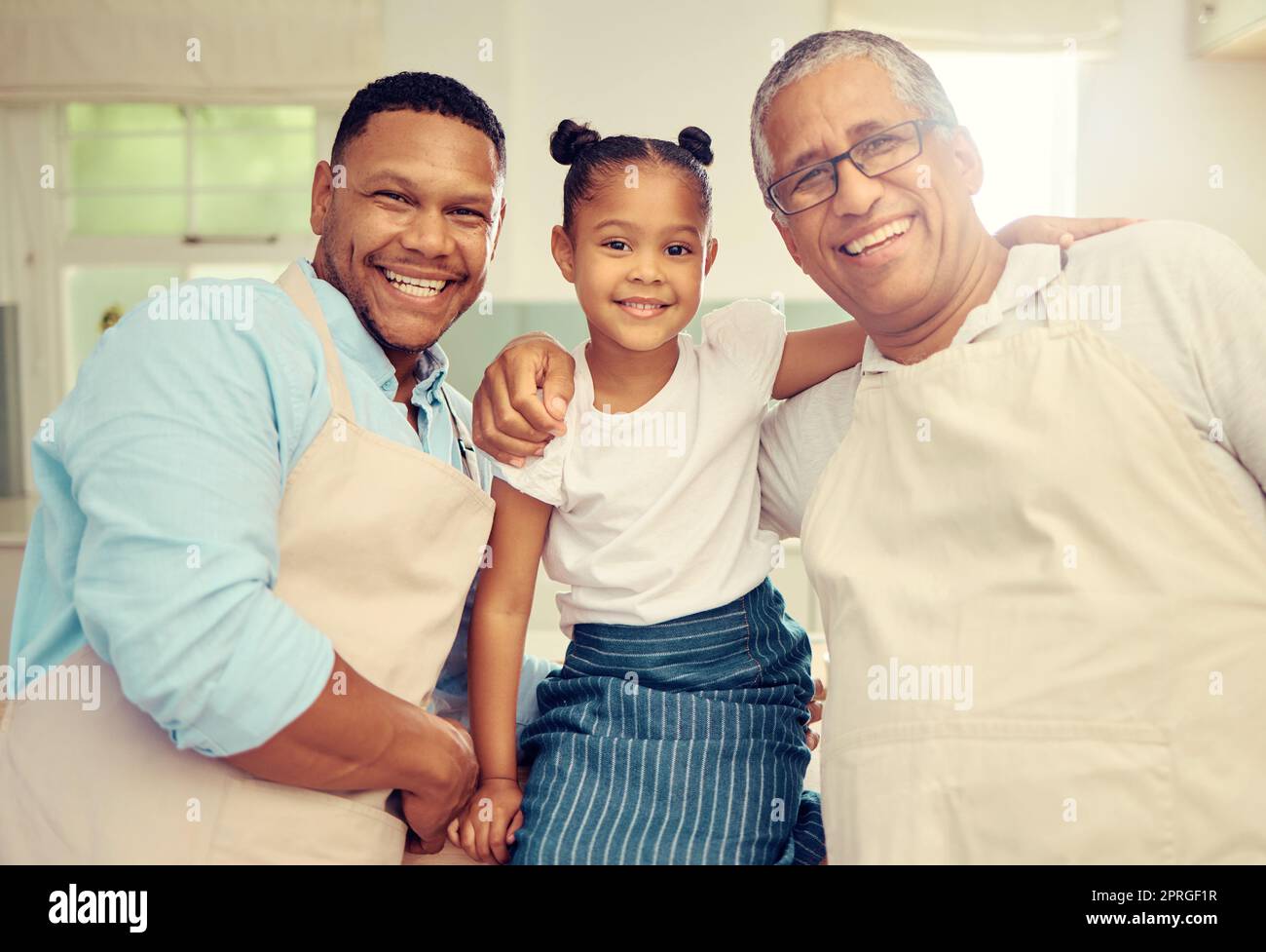 Porträt einer glücklichen Familie nach dem Kochen oder Backen in einer Küche zusammen in einem Haus. Vater, Opa und Mädchen, die sich mit einem Lächeln, Glück und Liebe verbinden, während süßer und liebevoller Momente in der Küche Stockfoto