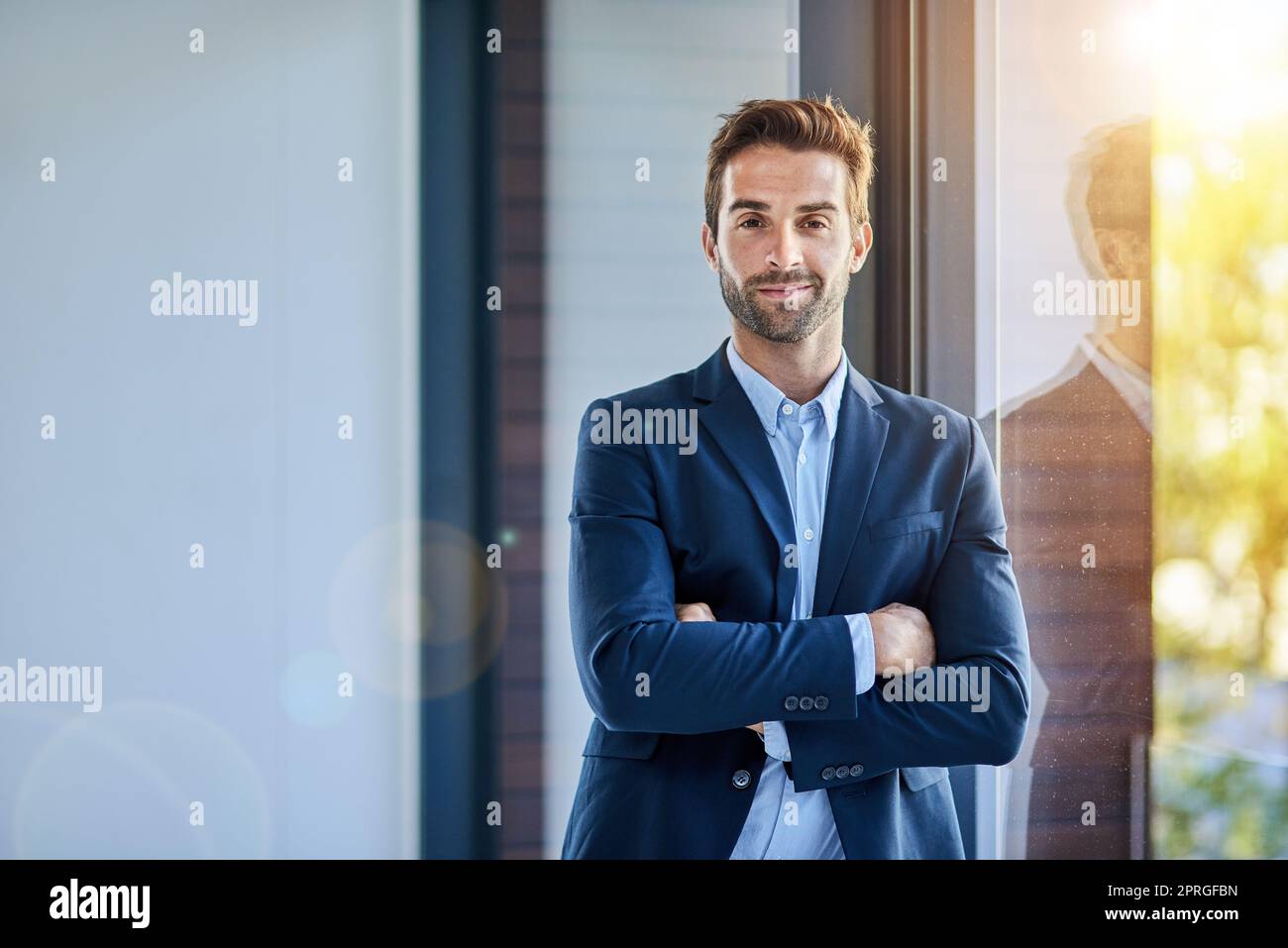 Ich bin durch positive Einstellung motiviert. Porträt eines jungen Geschäftsmannes, der in einem Büro steht. Stockfoto