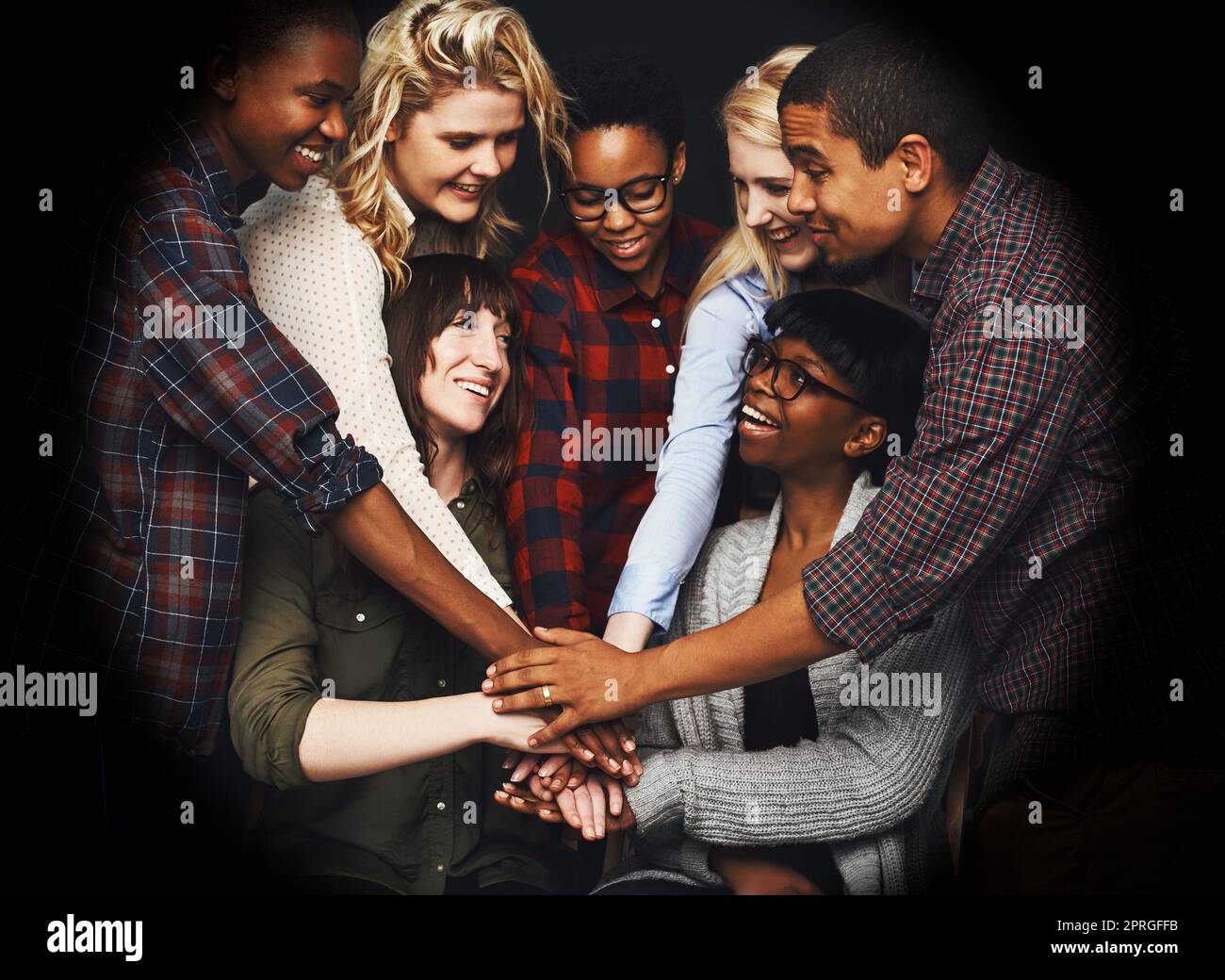 Eine für alle. Eine Gruppe von fröhlichen Arbeitskollegen, die sich zusammenfinden. Stockfoto