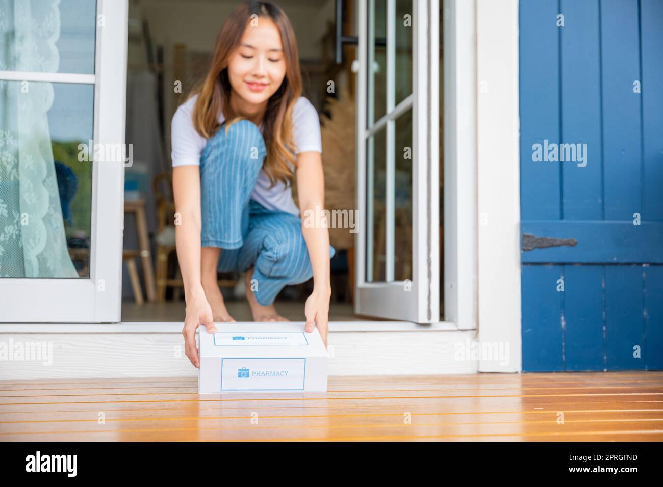 Nahaufnahme der Hände einer kranken asiatischen Frau, die an der Tür sitzt, um Medikamente erste-Hilfe-Apotheke-Box zu erhalten Stockfoto