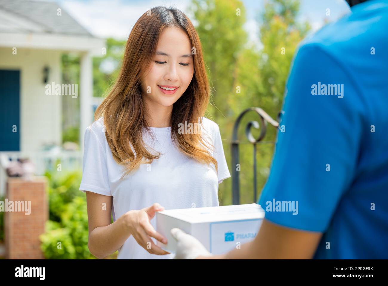 Kranke asiatische junge Frau erhalten Medizin erste Hilfe Apotheke Box vom Krankenhaus Lieferservice Stockfoto