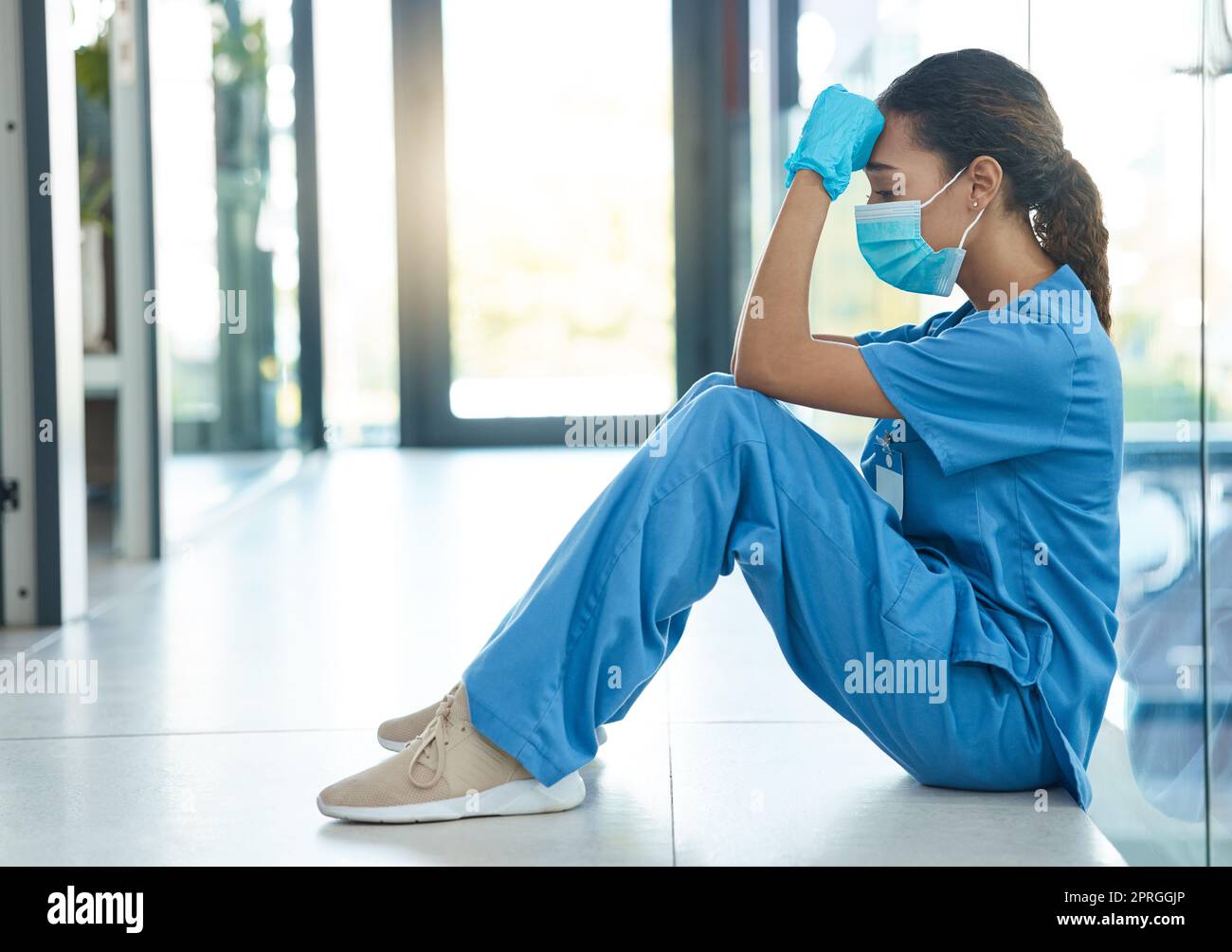 Jede Krankenschwester fühlte sich zur Pflege hingezogen. Eine Krankenschwester sieht gestresst aus, während sie im Krankenhaus sitzt Stockfoto