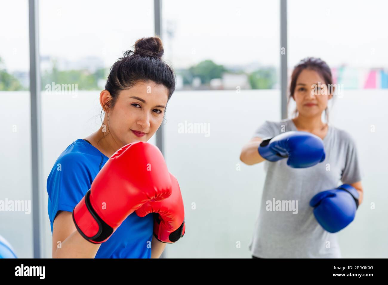 Erwachsene und junge Frau lächeln Sport Boxer mit Handschuhen beim Kick-on-Boxen Stockfoto