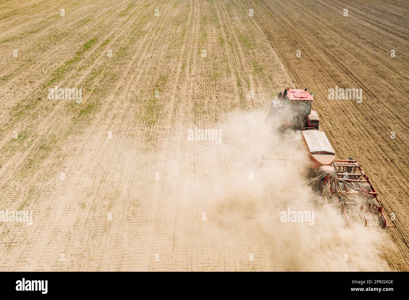 Luftaufnahme. Traktor Mit Samenbohrmaschine, Der Im Frühjahr Samen Für Erntegut Aussät. Beginn Der Landwirtschaftlichen Frühjahrssaison. Landschaftsbild Ländlicher Felder Stockfoto