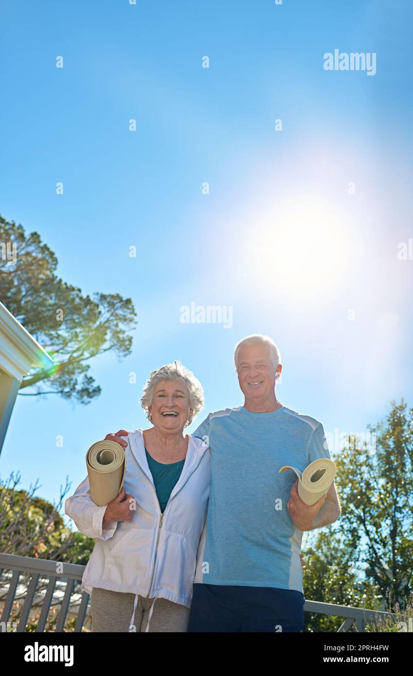 Gesund im Ruhestand leben. Porträt eines älteren Paares, das draußen steht und gemeinsam Yoga machen will. Stockfoto