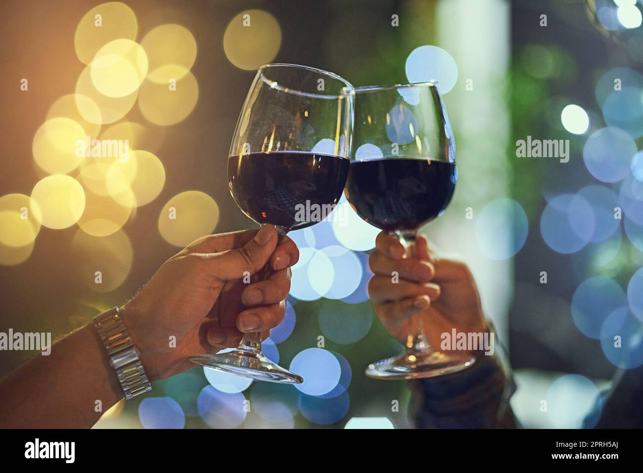 Heres to two people in love. Ein Paar klirren ihre Gläser, während auf einem romantischen Date. Stockfoto