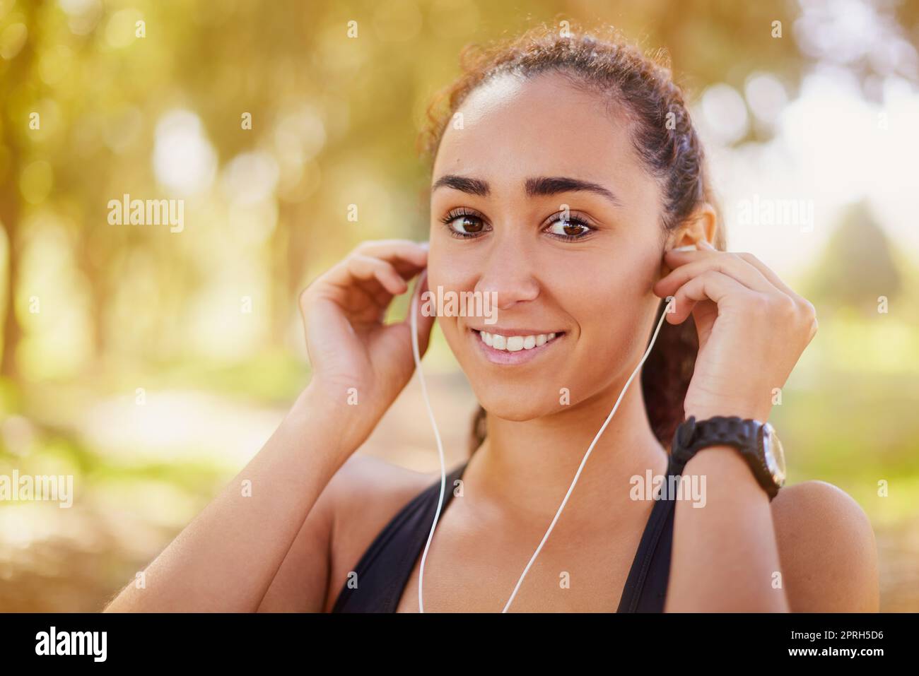 Bewegung im Allgemeinen ist gut für Ihr Selbstvertrauen. Ein sportlicher junger, der Musik hört, während er draußen trainiert. Stockfoto