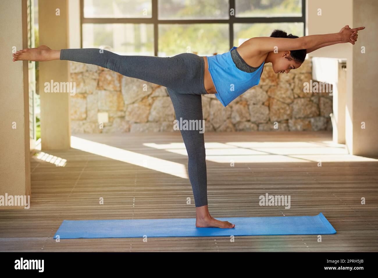 Steigerung ihrer Muskelkraft und ihres Tonus durch Yoga. Eine junge Frau, die zu Hause Yoga praktiziert. Stockfoto