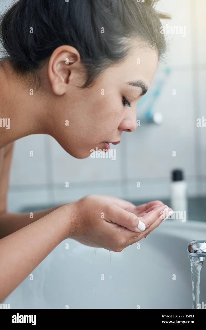 Wunder für ihre Haut durch eine konsequente Hautpflege Routine. Eine attraktive junge Frau waschen ihr Gesicht im Badezimmer. Stockfoto