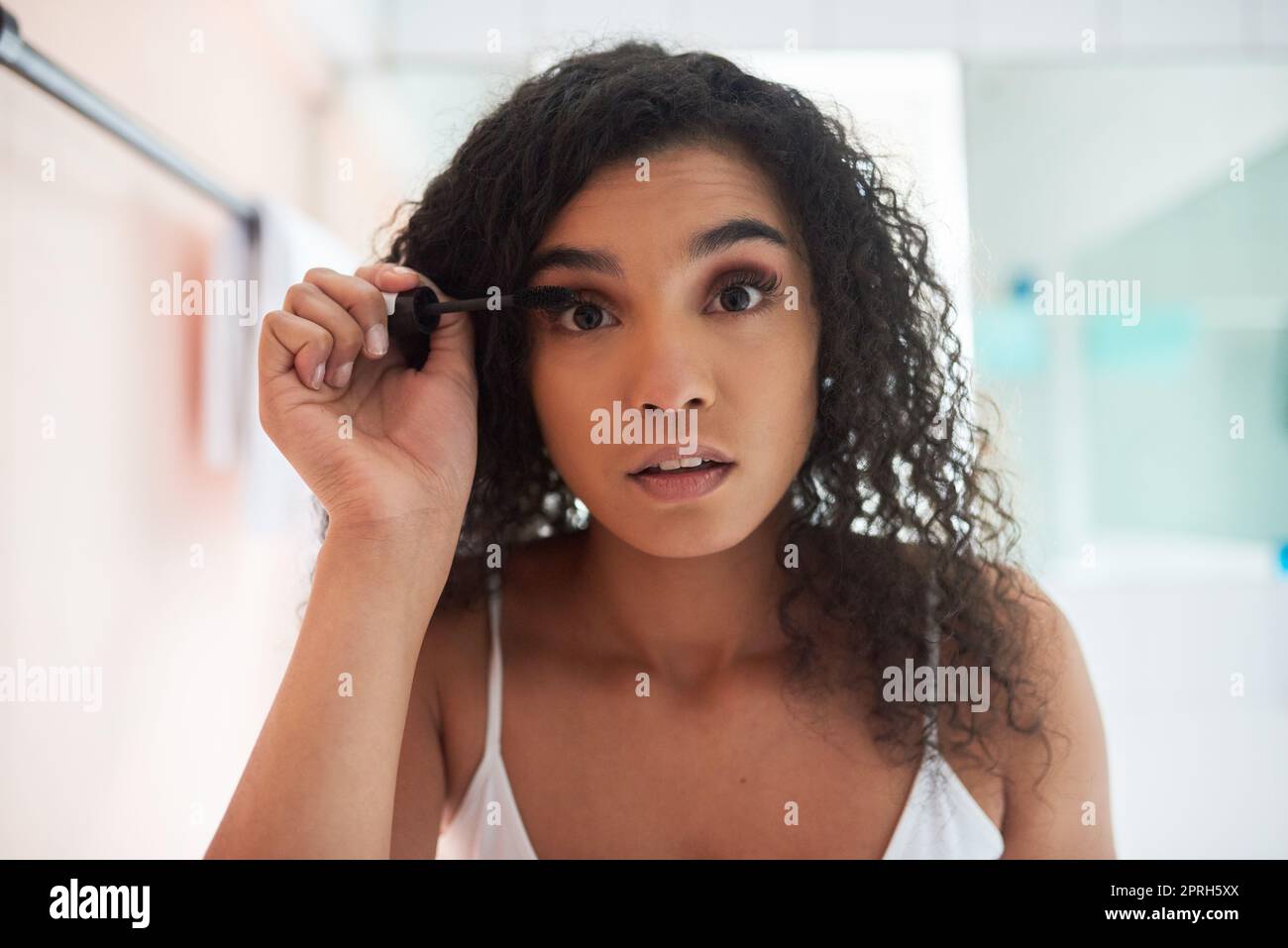 Ihre Augen knallen lassen. Porträt einer attraktiven jungen Frau, die Mascara im Badezimmer anwendet. Stockfoto