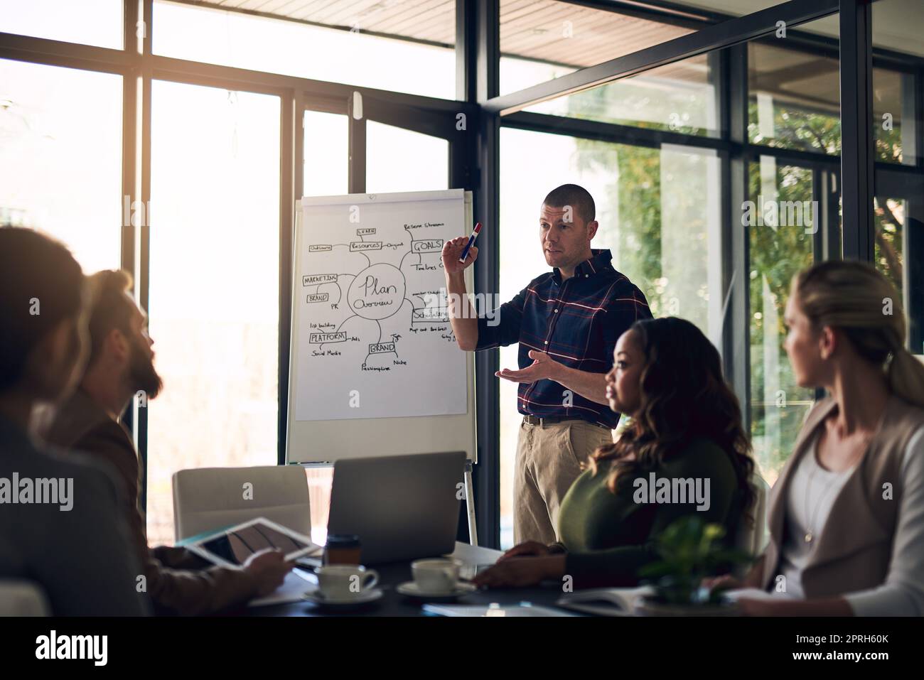 Vorbereitung auf den Erfolg. Ein motivierter Geschäftsmann, der eine Präsentation vor Arbeitskollegen in einem Sitzungssaal vorstellt. Stockfoto