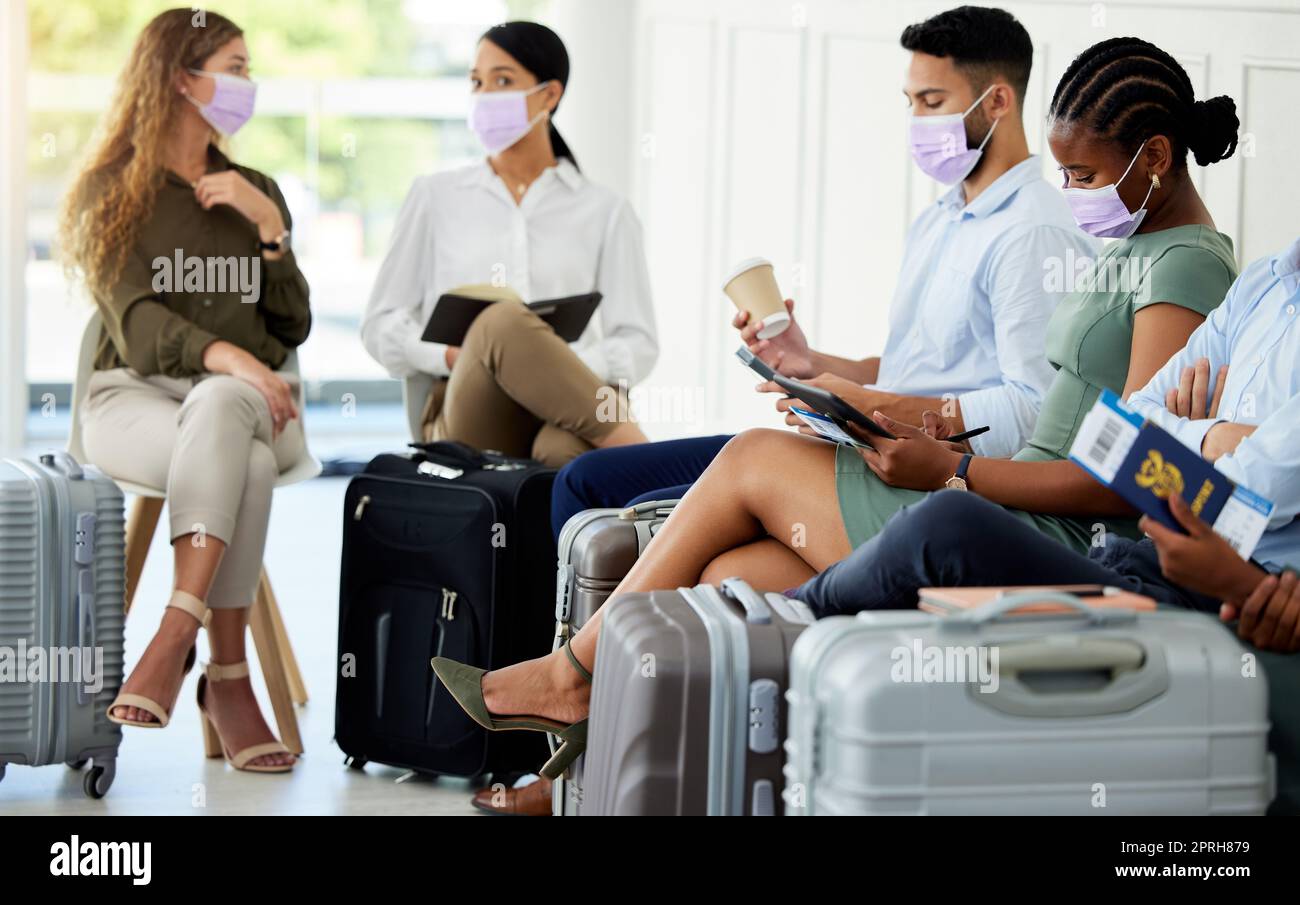 Vielfalt, lebhaft und Reisen von Menschen an einem Flughafen, die darauf warten, mit ihrem Pass und ihrer Maske an Bord eines Flugzeugs zu gehen. Eine Gruppe von Geschäftsleuten befolgt das Sicherheitsprotokoll für Reisen mit Gepäck im Falle einer Pandemie. Stockfoto