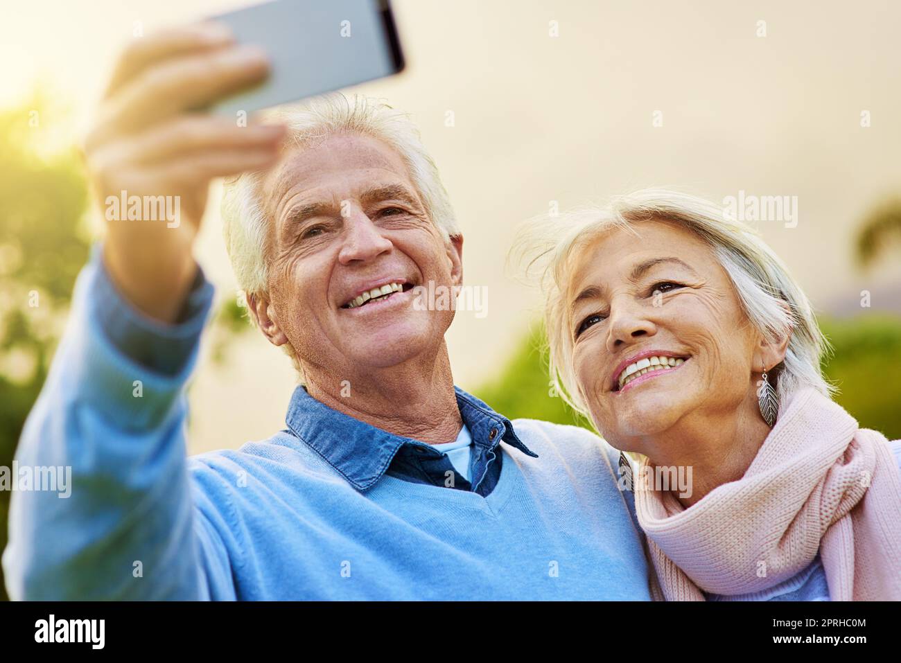 Ein Seniorenpaar, das zusammen in einem Park ein Foto macht. Stockfoto