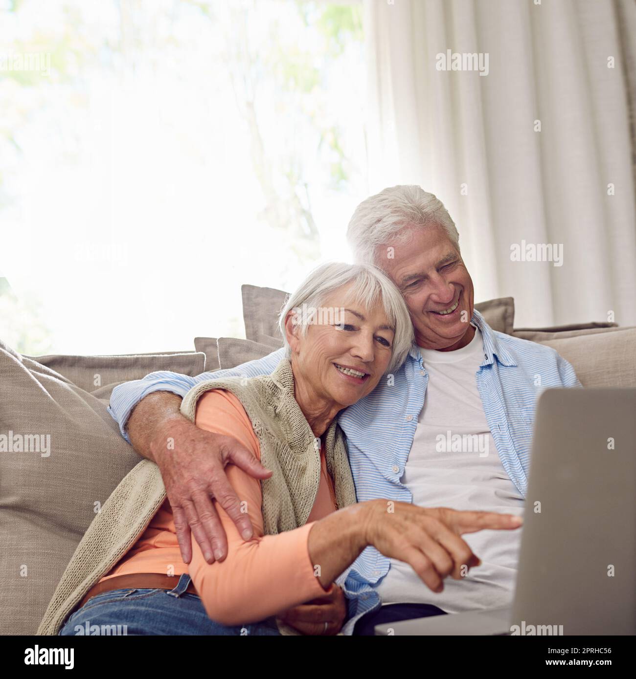 Das sollte unser nächstes Urlaubsziel sein. Ein Seniorenpaar, das zu Hause einen Laptop benutzt. Stockfoto