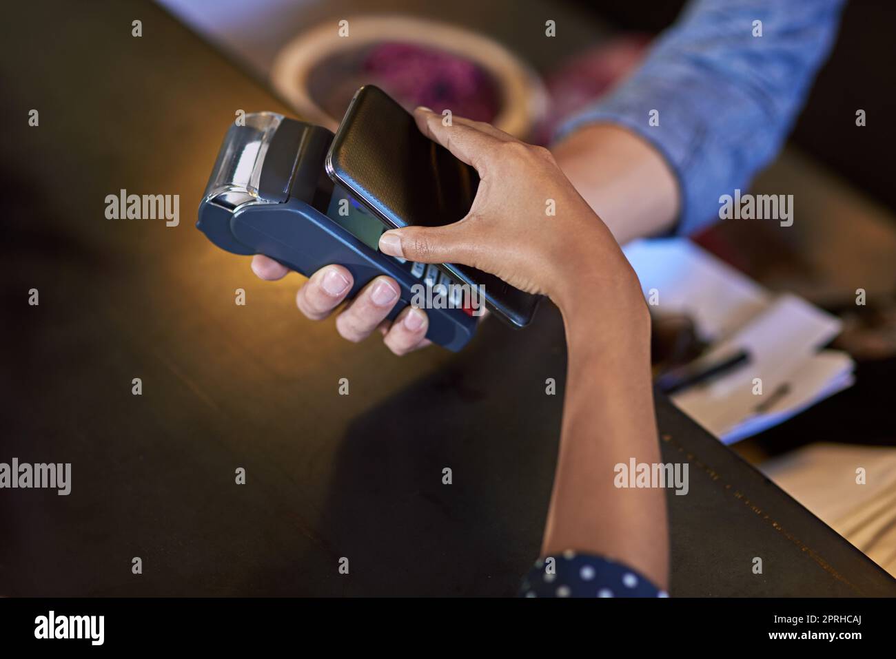 Vereinfachung der Ausgaben. Eine Frau, die in einem Café mit NFC-Technologie bezahlt. Stockfoto